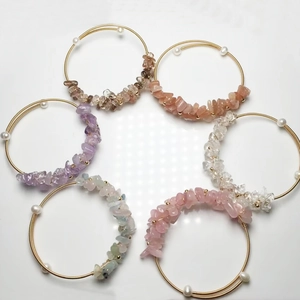 Flat lay macro of handmade 14K gold wire wrapped crystal gravel bracelets with freshwater pearl