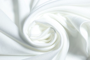 Vue détaillée du tissu synthétique blanc texturé avec drapé doux et motif de maille