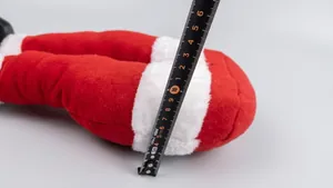 Detailed measurement showing the 12cm width of the plush Christmas elf leg decoration