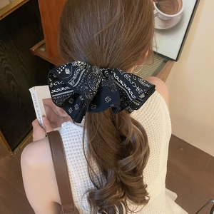 Détail d'un serre-tête nœud en tissu noir avec motifs paisley sur un mannequin