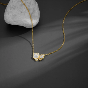 Elegant gold butterfly necklace with shimmering silver crystals on gray textured stone