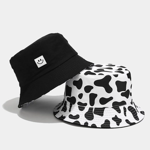 Reversible cow print and black smiley bucket hat for outdoor sun protection