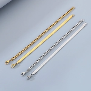 Detail of gold and silver snake and curb chain bracelets on a dark background