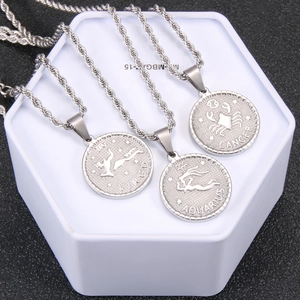 Detailed macro view of three 18K gold zodiac coin necklaces on a hexagonal stand