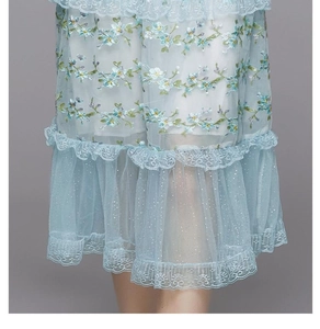 Détails de broderie en dentelle bleu clair et volants en maille sur une robe élégante
