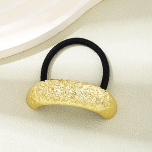 Detailed view of black elastic hair tie with textured gold metallic curve accent