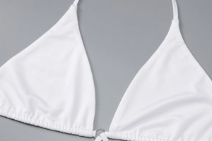 Détail d'un maillot de bain en maille blanche avec anneau métallique et coutures fines