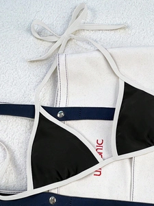 Detail of color-block bikini top with black fabric and white tie-neck strings
