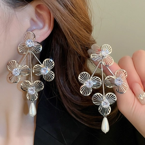 Silver flower earrings with zircon and drop pearls on model for a refined look