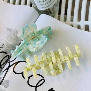 Close-up of acetic acid hair clips in marble patterns on a lifestyle magazine