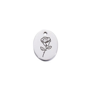 Macro detail of silver stainless steel oval pendant with engraved rose flower pattern