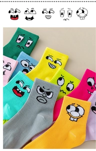 Flat lay of colorful knitted cotton socks with assorted cartoon smiley face expressions