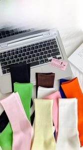 Vibrant ribbed cotton socks in various colors displayed on a laptop and desk background