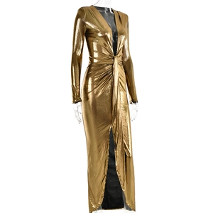 Détail du tissu doré métallisé sur une robe à col en V avec des plis à la taille