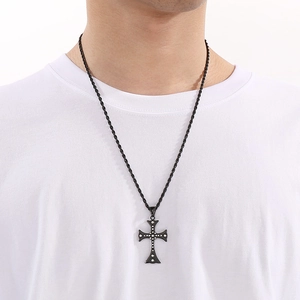 Close-up of men's black cross pendant with rivet details on a rope chain necklace