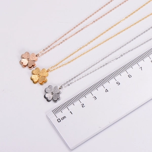 Macro detail of 1.5cm clover pendants in rose gold, gold, and silver matte titanium steel