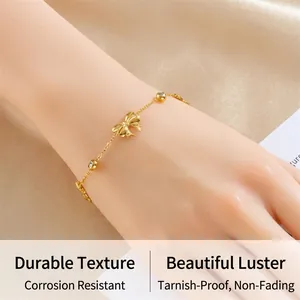Close-up of gold stainless steel bow bracelet with tiny round inlaid crystals on silk