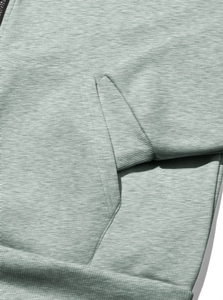 Detail of high-density knit fabric and reinforced stitching on a green zip-up hoodie