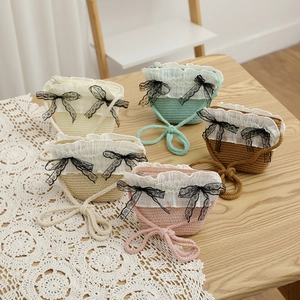 Détail de cinq sacs en paille tissés à la main en couleurs variées avec dentelle et nœuds