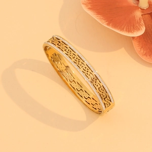 Macro detail of gold-plated hollow Celtic knot bangle with sparkling white rhinestones