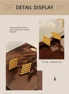 Detail shot of golden geometric rhombus stud earrings with intricate beaded texture