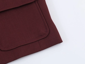 Detail of burgundy tweed jacket pocket with textured fabric and clean stitching