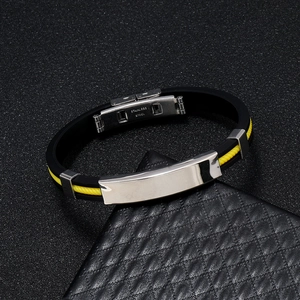 Gros plan sur le fermoir en acier et le bracelet en silicone jaune tressé sur cuir