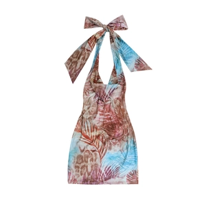 Detail of tropical halter neck dress featuring a large bow tie and vibrant leopard print