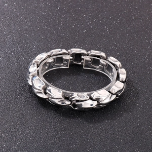 Detail of silver punk dragon bone steel bracelet with rugged lava stone texture