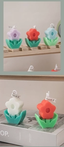 Detailed close-up of dual-color flower-shaped scented candles with green leaf base