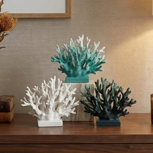 Three coral resin sculptures in white, turquoise and dark green on square bases