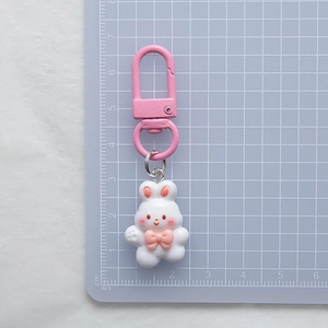 Close-up of cute pink bunny keychain with bow on a centimeter scale measuring pad
