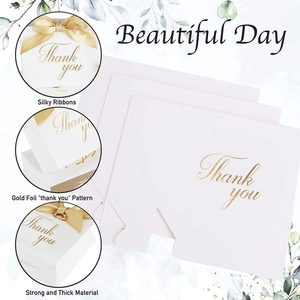 Détail boîte cadeau blanche avec marquage à l'or Thank You et un ruban en soie doré chic