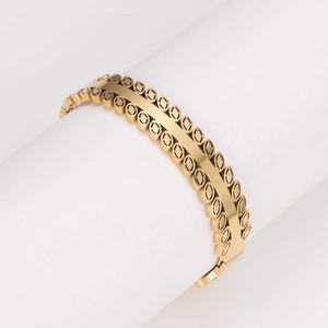 Elegant gold leaf buckle stainless steel bracelet displayed on a white jewelry stand