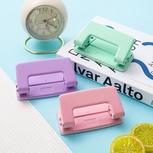 Nahaufnahme von Mini-Lochern in Pastellgrün, Violett und Rosa auf blauem Hintergrund