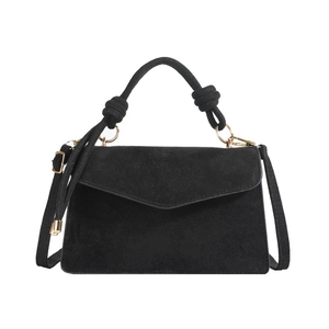 Minimalist black suede handbag with knotted top handle and adjustable gold strap