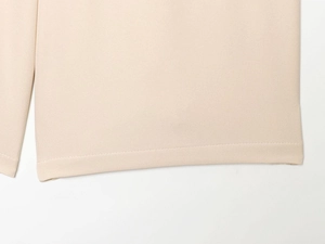 Gros plan d'un pantalon décontracté beige montrant le tissu sergé et les détails de couture