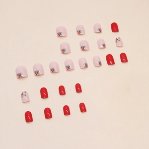 Short square press-on nails with red berry and leaf patterns in glossy red and nude pink