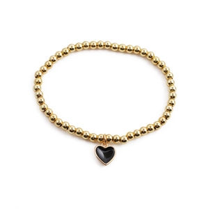 Golden beaded bracelet with a black enamel heart pendant on a clean white background