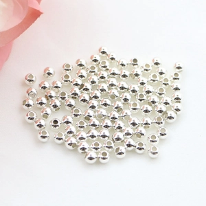 Macro shot of silver metal spacer beads for DIY jewelry with soft floral accents