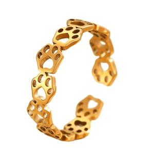 Detailed view of hollowed-out pet paw prints on a polished gold-plated adjustable ring