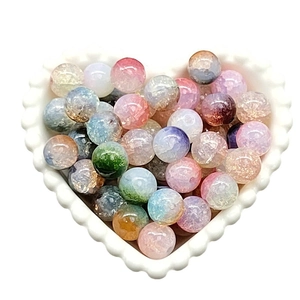 Colorful ice-cracked glass beads for DIY jewelry displayed in a heart-shaped ceramic bowl