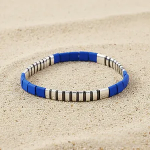 Detail of blue and striped enamel tile beads on a Bohemian beach-style elastic bracelet