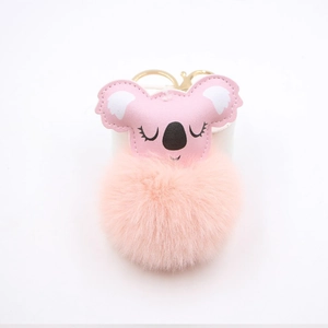 Close-up of pink faux leather koala head with soft plush pompom and gold keychain