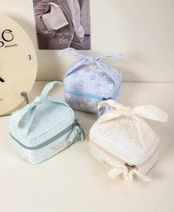 Detail of jacquard floral toiletry bags with bow knot straps and MiloBliss logo labels