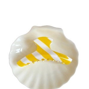 French vintage yellow striped acetate hair claw clip barrette on shell dish