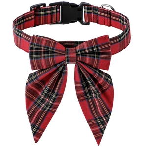 Close-up of red and green plaid dog collar with a bow tie and black plastic buckle