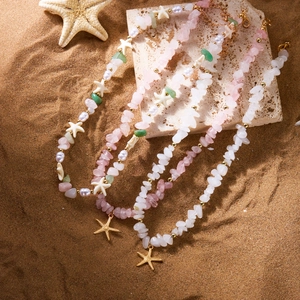 Bohemian beach necklace set with natural stones, pearls and starfish charms on sand