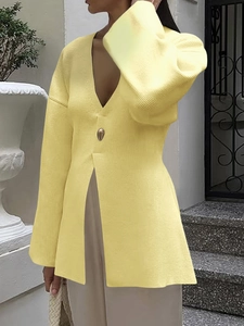 Close-up of elegant pale yellow ribbed knit cardigan with deep V-neck and single large button