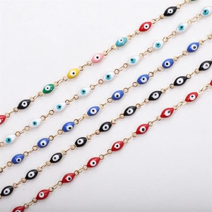 Detailed macro view of colorful enamel evil eye charms on golden stainless steel chains